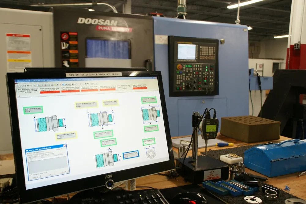 Mitutoyo MeasurLink SPC software charting in-process part dimensions beside one of three Doosan Puma TT1800SY mill-turn centers — live statistical process control at the machine