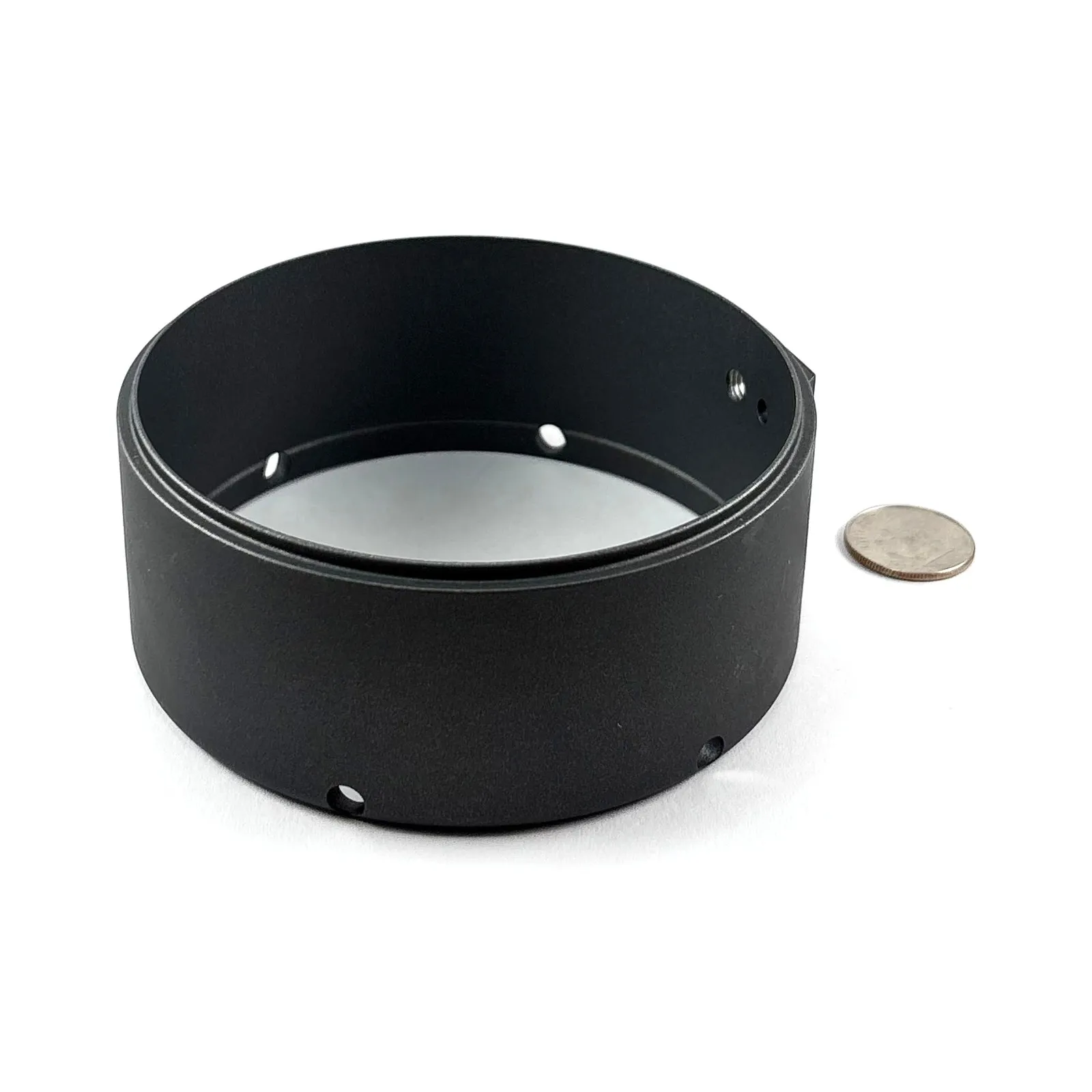 A black-anodized aluminum ring / shroud with machined through-holes and a stepped bore