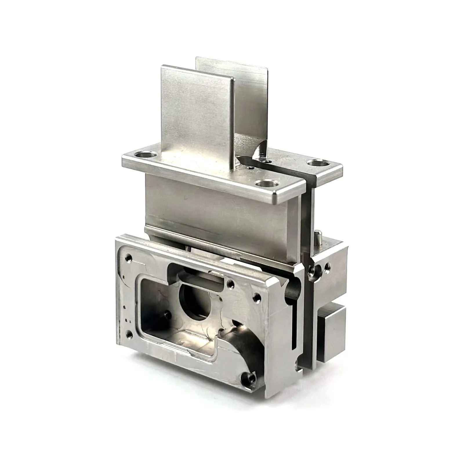 A complex milled stainless steel housing with mounting flanges and a pocketed window — multi-axis milling in the Swiss department