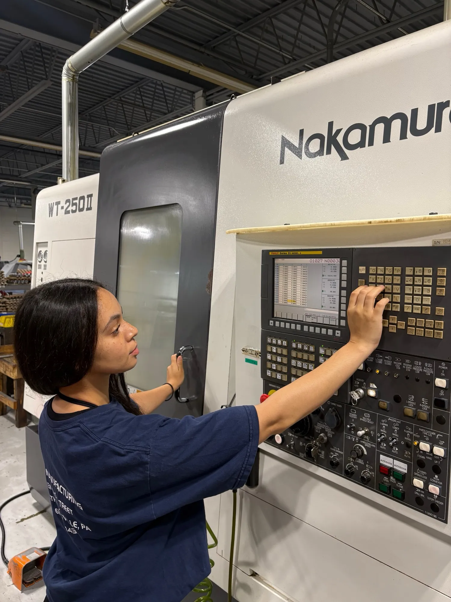 A CNC Manufacturing machinist operating the control of a Nakamura-Tome WT-250 mill-turn center